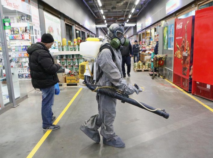A specialist wearing protective gear sprays disinfectant inside the FOOD CITY wholesale and retail market to prevent the spread of the coronavirus disease (COVID-19) in Moscow, Russia April 9, 2020. Andrey Nikerichev/Moscow News Agency/Handout via REUTERS